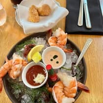 An assortment of seafood on ice in a black tray.