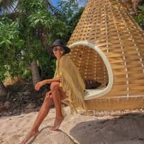A woman enjoying a serene moment by the beach, on an outdoor wooden swing at Punta Mita