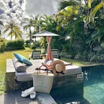 A guest lounging on a poolside daybed