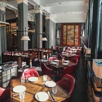Elegant dining room, featuring wood tables and red leather chairs, creating a warm atmosphere