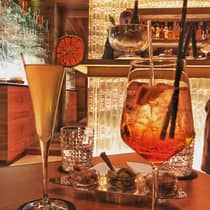 Amber cocktails, orange garnish by crystal glasses on lounge table