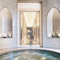 Decorative white screen around small round spa whirlpool