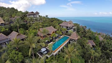 Aerial view of owner's residence villa complex around blue swimming pool, patio on tropical mountain