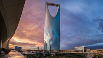 Looking up at modern Four Seasons Hotel Riyadh at Kingdom Centre tower skyscraper at sunset