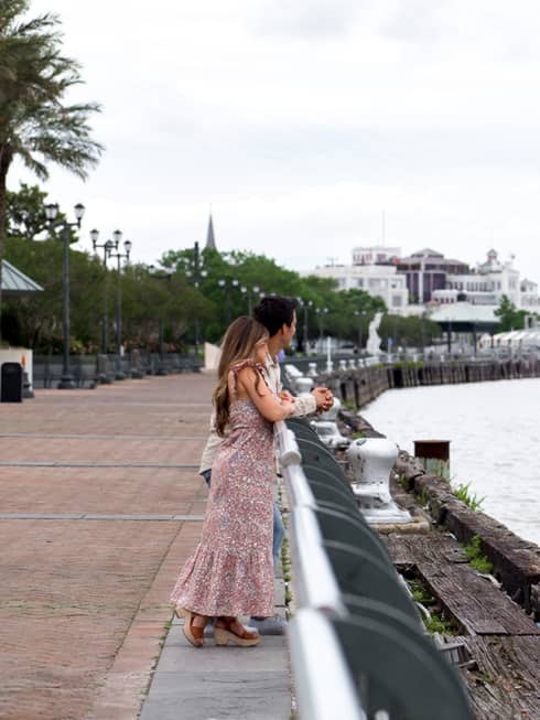 A woman and man looking out a river.