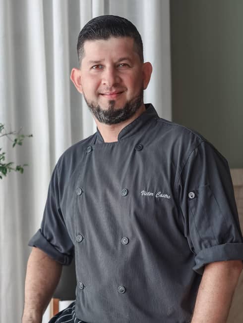 A chef in a grey chef's coat.