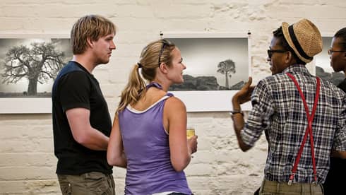 Four people discuss black and white art prints at Museum in Maboneng 
