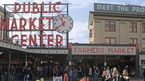 Crowds gathered outside Pike's Place Market, under signs
