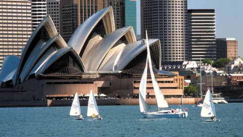 White sail boats on Sydney Harbour in front of opera house