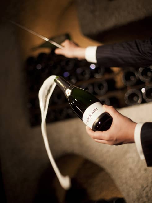 Person pouring champagne out of a champagne bottle.
