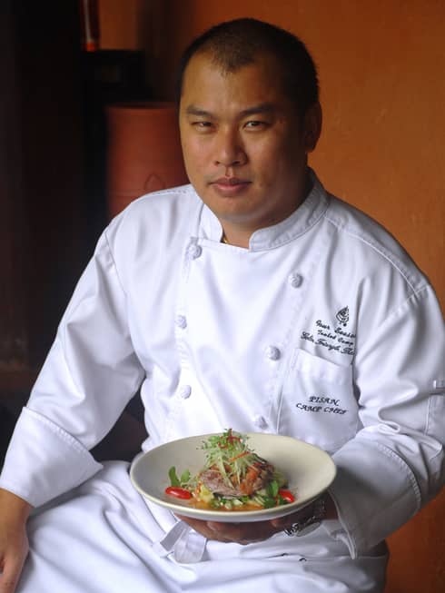 Portrait photo of Camp Chef Pisan Torphet wearing white uniform, holding bowl