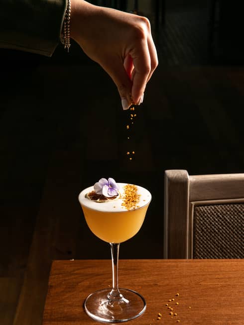 A cocktail being garnished.