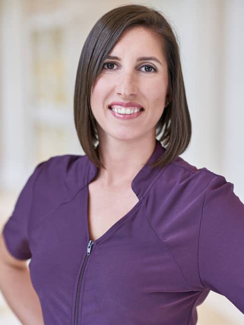 Smiling woman wears purple spa attire