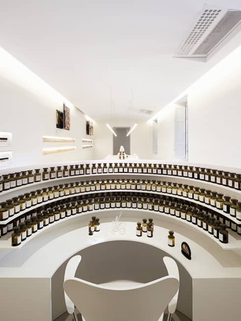 Curved white shelves with small glass tincture bottles at the Fragonard perfume factory