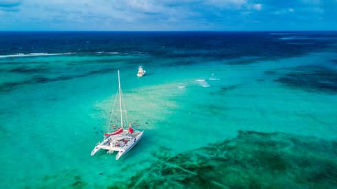 Aerial view of a catamaran sailing turquoise-blue waters