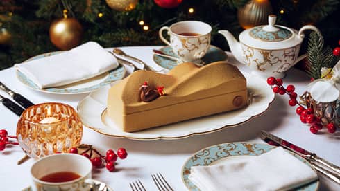 B�che de No�l designed to look like a dessert sand dune with a decorative camel wearing a red Santa hat