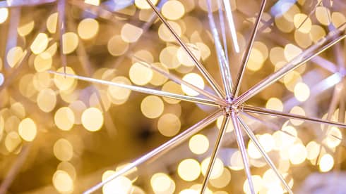 A pointy gold ornament surrounded by small yellow lights.