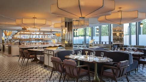 Indoor restaurant with booths and chairs, large ceiling lights, tiled floor