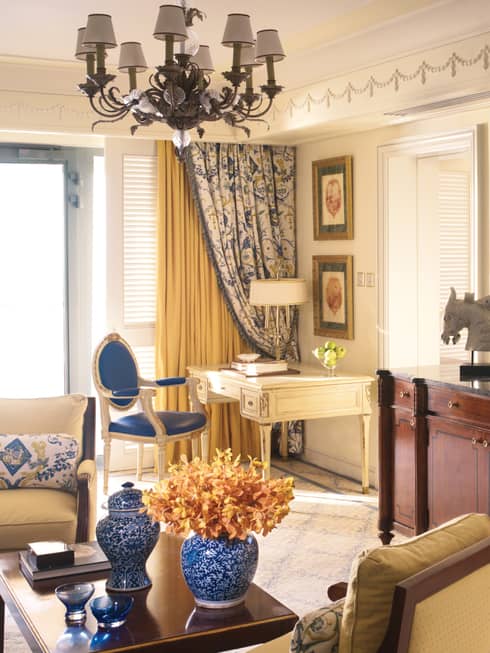 Sea-View One Bedroom Suite table with blue-and-white vases, cherry-wood dresser, flat-screen TV