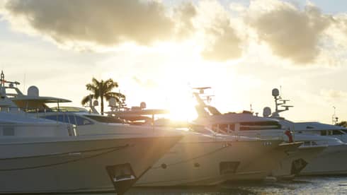 Yachts lined up on water at sunset