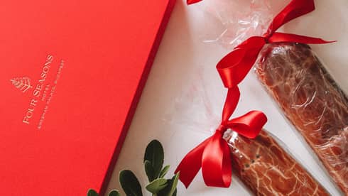 Red Four Seasons gift box, mistletoe, amaryllis and two wrapped Beigli with red bows