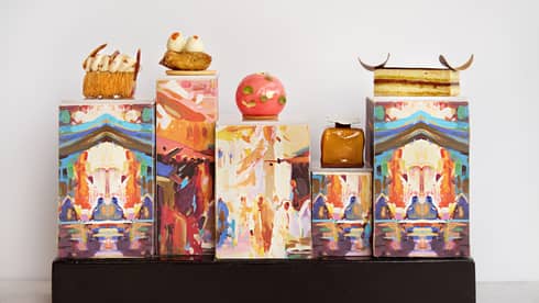 Small pastries placed on top of rectangles decorated with works of art
