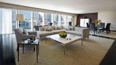 Chairman's Suite modern L-shaped grey sofa, armchair coffee table, wall of windows