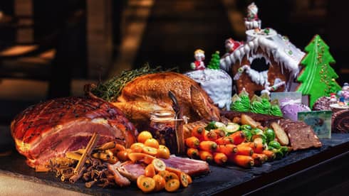 Christmas dinner with turkey and vegetables with gingerbread house on the side