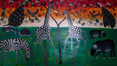 Colourful painted mural of giraffes, zebras, hippos, birds