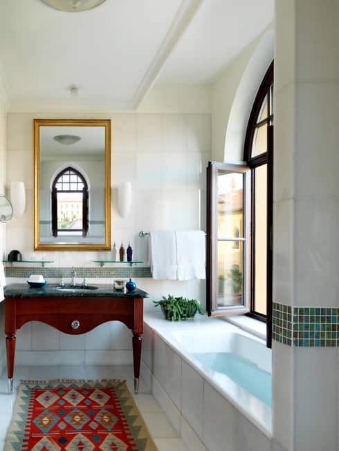 Small tub under open window in bright bathroom with sink