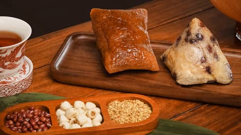 Rice dumpling set with tea on a wooden table with red flowers