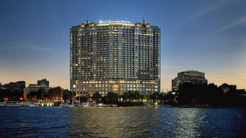 Hotel exterior illuminated at night with the Nile River below