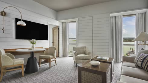 Luxury living room with grey sofa, armchair and two-seater table overlooking a river