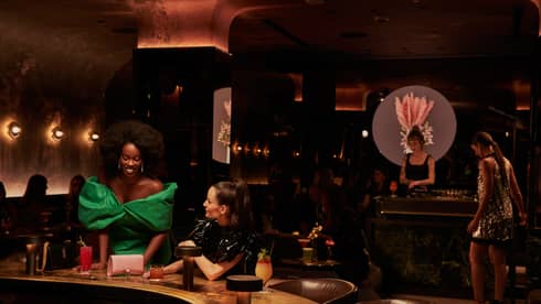 Two women in dresses at a bar.