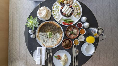 A variety of breakfast dishes presented on a round black marble table