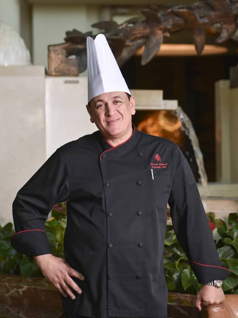 Chef from Four Seasons Hotel Doha stands near a fired oven