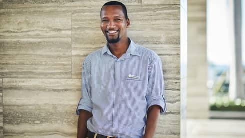 Portrait image of smiling personal assistant standing against marble wall