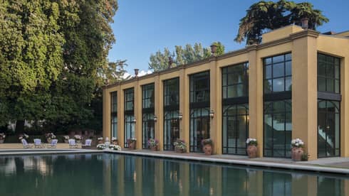 A large swimming pool and lounge area in the back of the hotel