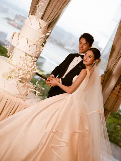Bride and groom cut large wedding cake