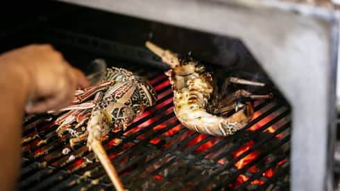 Seafood being cooked on a grill.