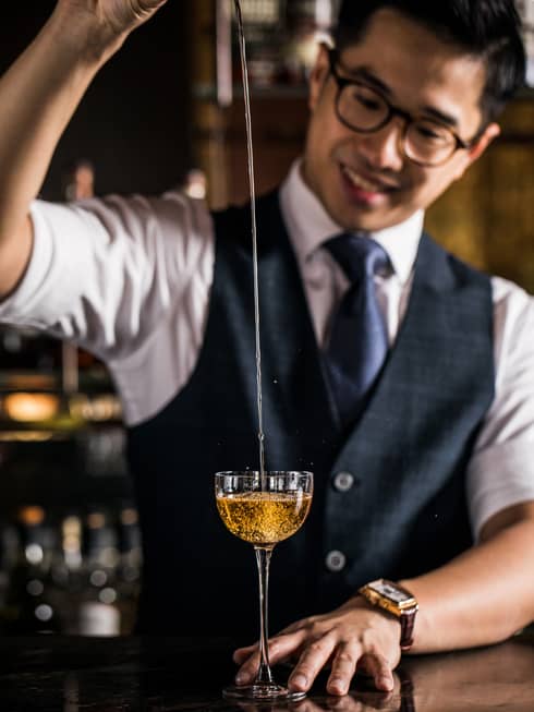 Assistant Bar Manager Adam Lau pours a cocktail