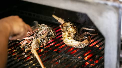 Seafood being cooked on a grill.