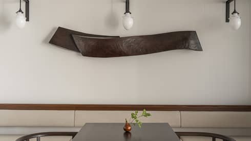 Minimalistic Japanese tea table with two seats and three pendant lights overhead