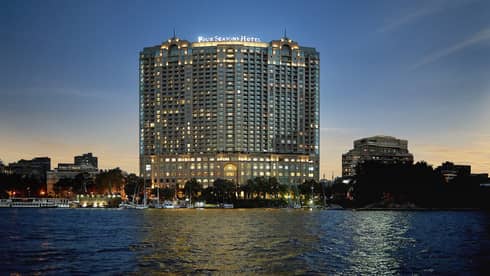 Hotel exterior illuminated at dusk, along the Nile River