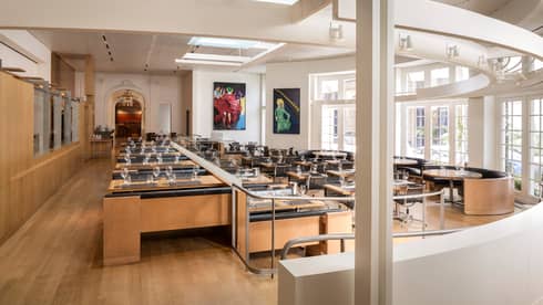 CUT restaurant bright dining room, rows of tables, curved white wall and window