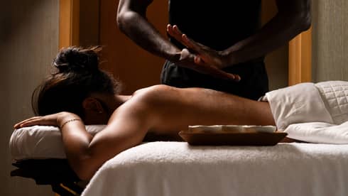 Guest laying on a massage table while the massage therapist prepares for the massage.