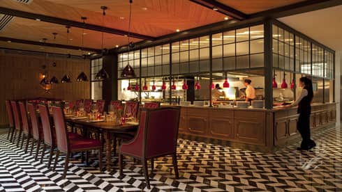 Elena is a warm dining atmosphere with black and white tiled floor and red accents 