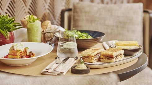An assortment of pasta, salad and sandwiches on a small table.
