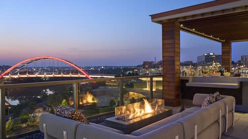 A fire pit by a sofa on a rooftop terrace.