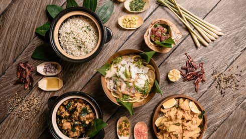 Aerial view of rustic wood table with bowls of gourmet rice, salads and entrees 